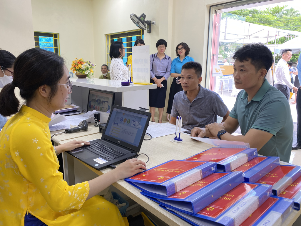 cán bộ bưu điện hướng dẫn người dân nộp thủ tục hành chính qua Cổng dịch vụ công trực tuyến