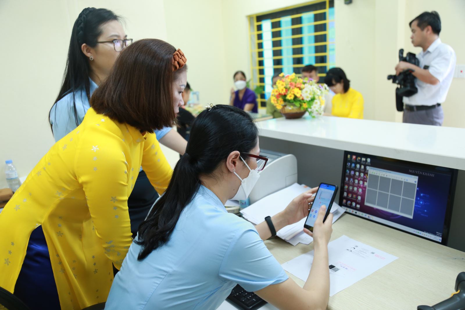 Cán bộ trung tâm hành chính công thành phố hướng dẫn cán bộ bưu điện phường Việt Hưng cài đặt và thao tác phần mềm ứng dụng thực hiện các dịch vụ hành chính trên thiết bị điện thoại di động